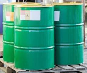 Three green barrels with label on wooden pallets