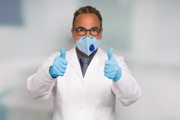 Doctor with medical face mask and medical gloves shows thumbs up