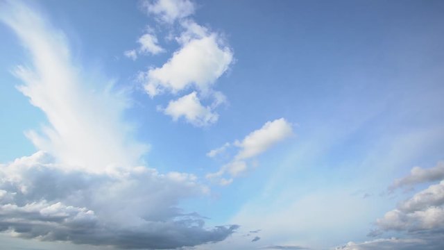 Video timelapse of beautiful clear sunny blue sky and peaceful fluffy white clouds flying overhead.
