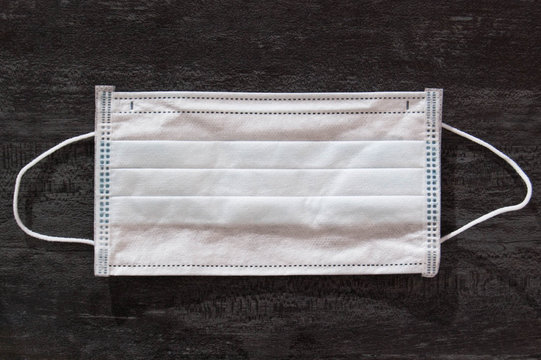 Medical disposable mask, horizontal photo with copy space and grey background, top view. 