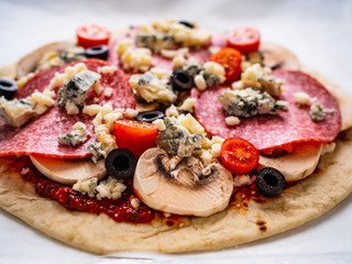 Uncooked pizza on white paper