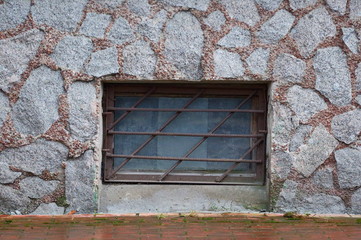 A basement window with a metal barrier