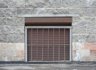 A basement window with a metal barrier