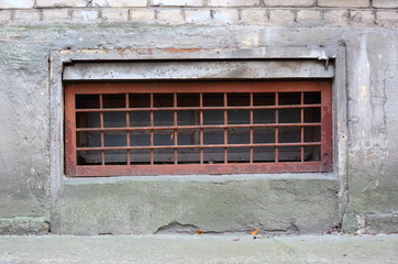 A basement window with a metal barrier