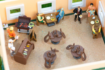 Social distancing rules with miniature people in a restaurant