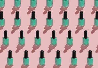 a pattern from nail enamel bottles with green enamel on pink background