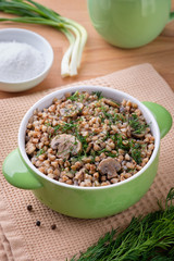 A bowl with buckwheat porridge and mushrooms, traditional russian food. Vertical orientation