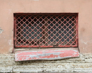 A basement window with a metal barrier