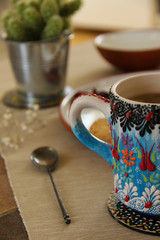 Obraz na płótnie Canvas Close up of a beautiful tea mug and vintage tea spoon. Tea break background.