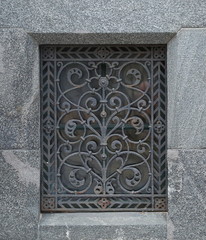 A basement window with a metal barrier