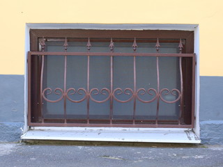 A basement window with a metal barrier