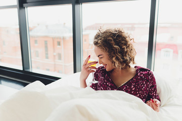 Woman on Hotel Bed Covering Self With Sheet.