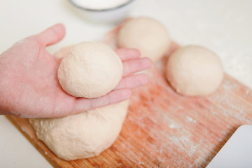 man's hand making pizza flour in home kitchen