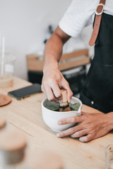 A brush made of bamboo and a teacup with green tea called matcha on wooden tray made by professional barista in Asian cafe.Green tea powder being stir in a white ceramic bowl.Tea ceremony in oriental 