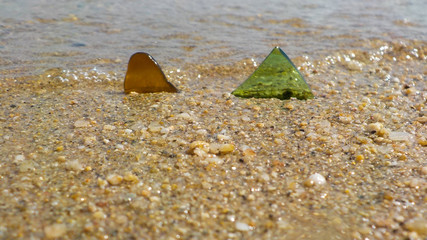 Fototapeta na wymiar Pezzi di vetro colorati sulla spiaggia.