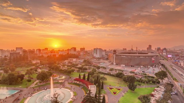 Aerial sunset view of the National stadium in the Peruvian capital Lima with Via Expresa highway timelapse. Landscape of Park of the Reserve and city skyline on a background in South America. Peru