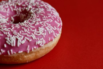 donut with sprinkles on red background 
