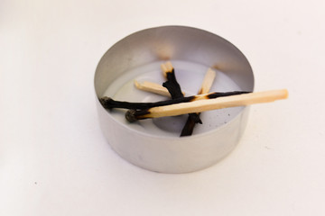 Burnt out matches with used candle on white background isolation exhausted tired concept