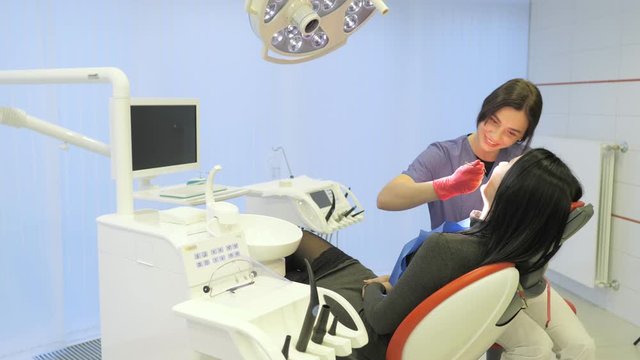 Female dentist doing dental treatment to her patient in clinic