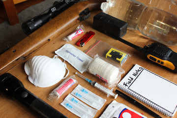Emergency evacuation survival grab bag gear or items displayed on a wooden table. 