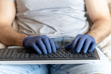 Hands in medical gloves on the keyboard. Communication, people and freelance work concept