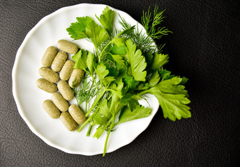 healthy food, alternative food, parsley in leaves and tablets on a white plate