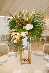 banquet table is decorated with plates, cutlery, glasses, candles and flower arrangements