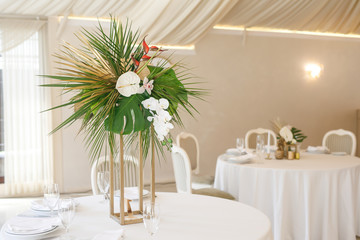 banquet table is decorated with plates, cutlery, glasses, candles and flower arrangements