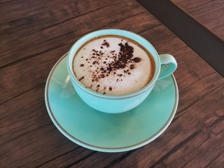 cup of cappuccino on wooden table in the cafe