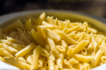 cooked italian penne rigate macaroni pasta draining