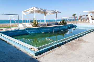 Abandoned beach club with bar in swimming pool. Tourism crisis concept.