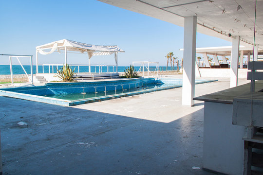Abandoned and closed beach club with swimming pool. Tourism crisis concept.