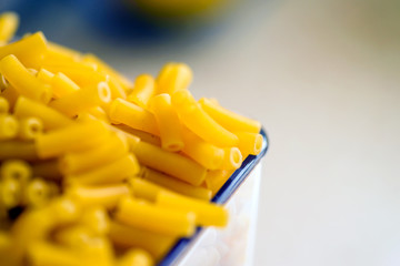 raw italian macaroni pasta inside clear storage container