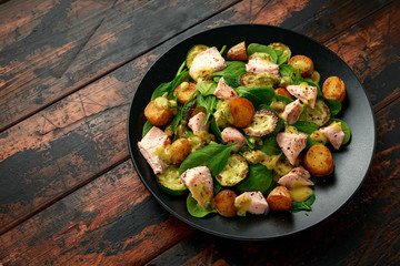 Salmon, new potato, courgette and spinach salad on wooden table