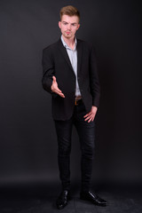 Portrait of young handsome blond bearded businessman in suit