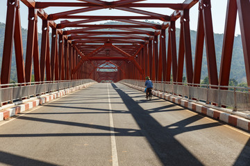A cyclist rides on the bridge. Bridge over the Mekong River. Sainyabuli Province, Laos
