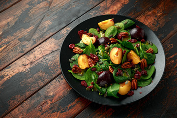 Vegan plums salad with cranberry, pumpkin seed, pecans nuts, spinach and mustard dressing