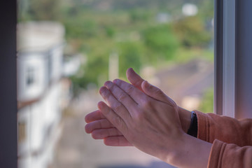 Hands clapping at the window for coronavirus doctors