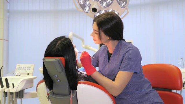 Female dentist doing dental treatment to her patient in clinic
