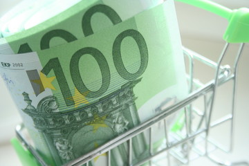 100 euro banknote in mini shopping trolley. Shopping cart concept or rich business.