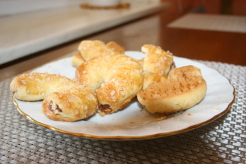 Sweet croissant cookies on white plate.