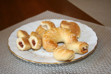 Sweet croissant cookies on white plate.