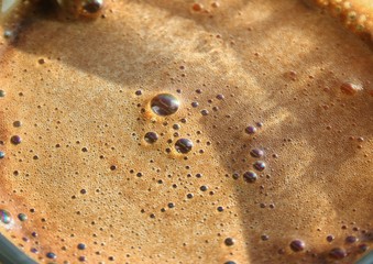 Bubble in coffee foam background. Brown macro coffee texture.