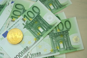 Golden Bitcoin cryptocurrency coin on Euro banknotes. New virtual money concept. Crypto financial background.