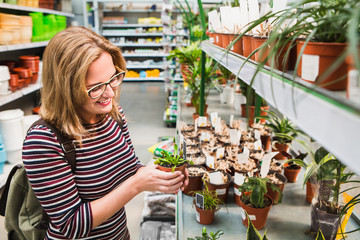 Woman chooses a flower in a garden store