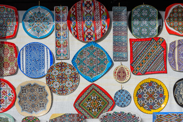 Many hand made plates and other pottery objects with traditional decorations displayed for sale as souvenirs at a street market fair in Bucharest, Romania
