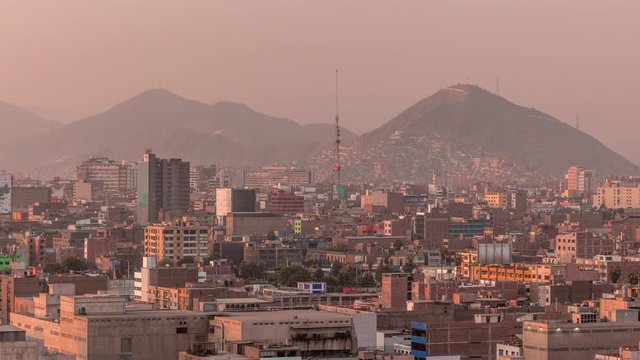 Panoramic skyline of Lima city from above with many buildings aerial timelapse during sunset. Poor houses with hills on a background. Traffic on streets. Lima, Peru