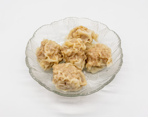 Chinese traditional delicacies, fresh meat wontons on clear plate isolated on white