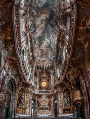 Ultrawide upward view of ceiling fresco altar facade inside Baroque style church Asamkirche in...