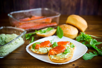 sandwich with fried bun, cheese spread and red fish in a plate